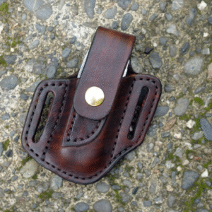 Front view of a Leatherman Charge multitool sheath shown in chocolate brown leather with a brass snap