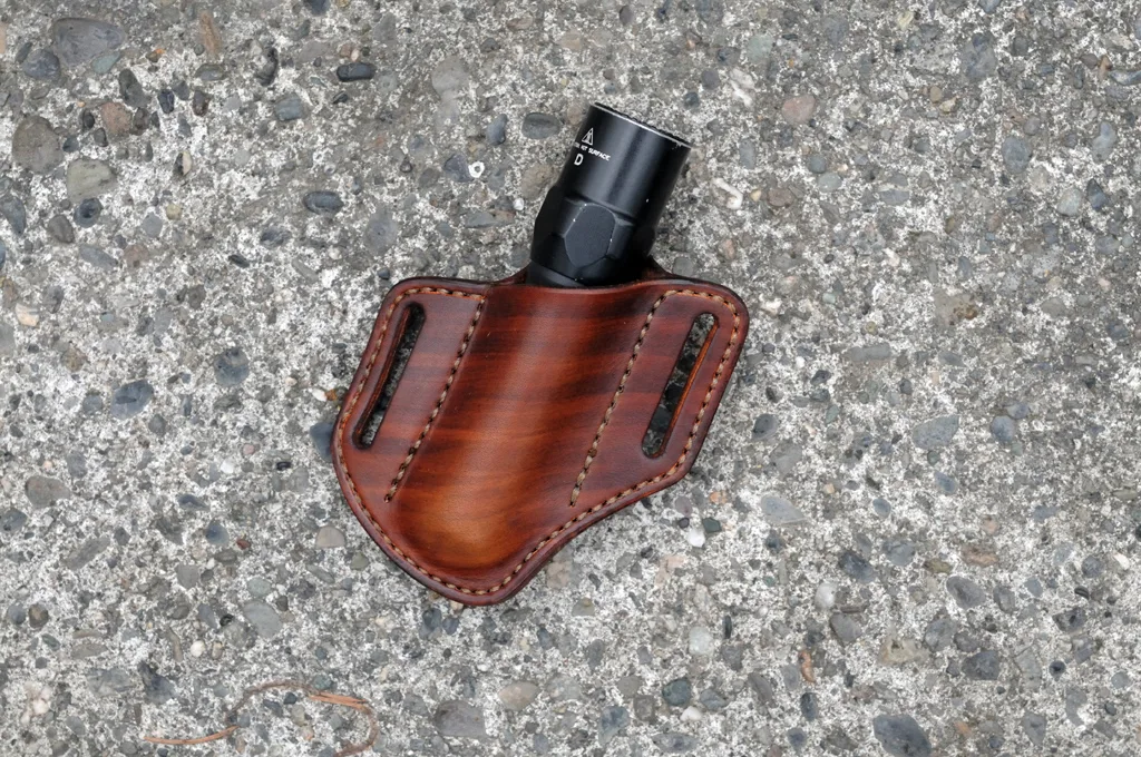 Front view of a leather belt sheath for a 1" every day carry flashlight shown in hand dyed brown leather