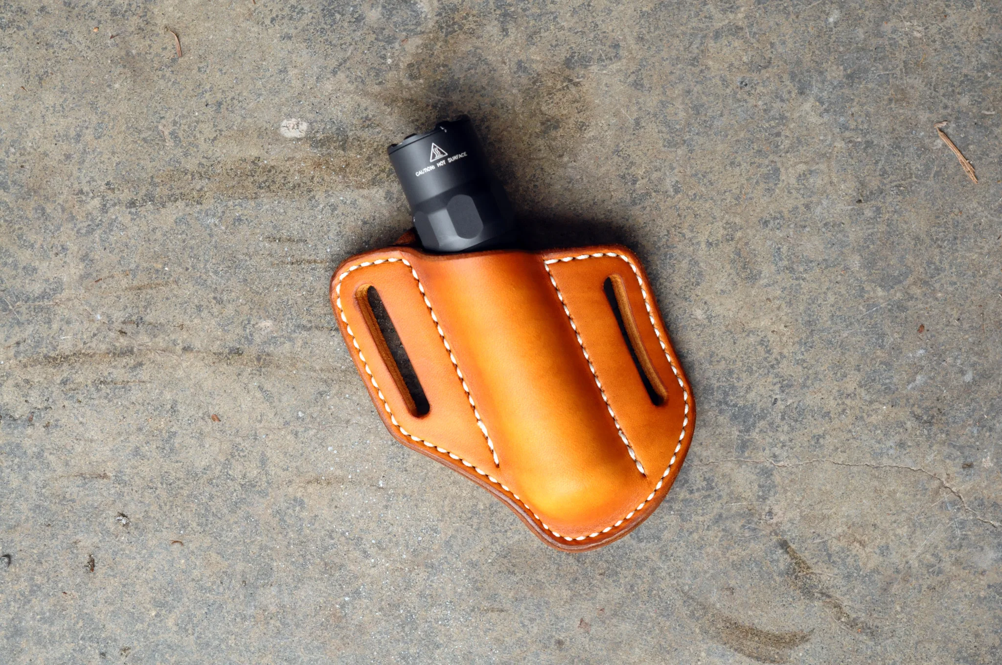 Front view of a leather belt sheath for a 1" everyday carry flashlight shown in hand dyed saddle tan leather