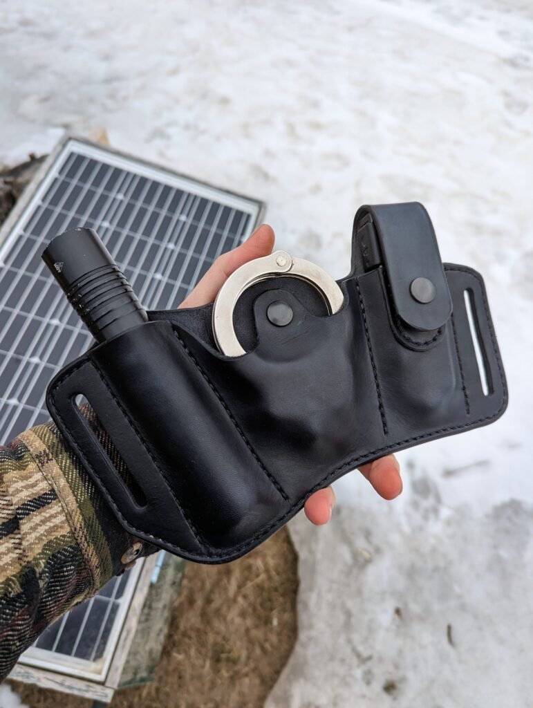 Front view of custom black leather holster for a Streamlight Protac 2L flashlight, Smith and Wesson handcuffs and Gerber MP600 multitool