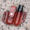 Front view of a sheath for a Leatherman Surge multitool and a flashlight shown in hand dyed mahogany leather configured for right side carry.