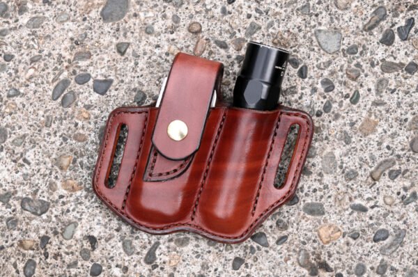 Front view of a sheath for a Leatherman Surge multitool and a flashlight shown in hand dyed mahogany leather configured for right side carry.
