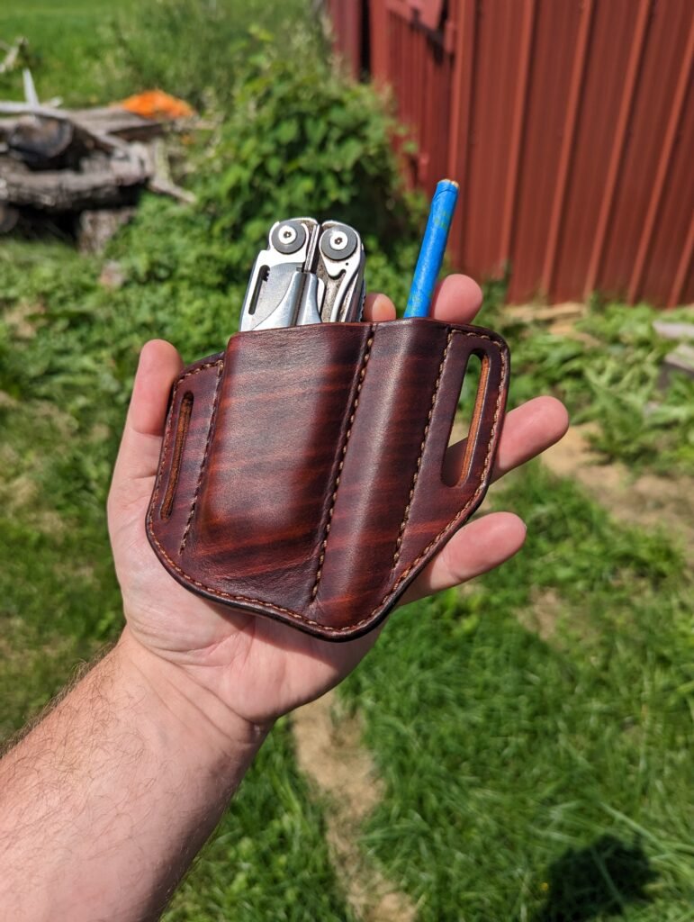 Front view of a sheath for a Leatherman Surge and writing pen made from hand dyed brown leather.