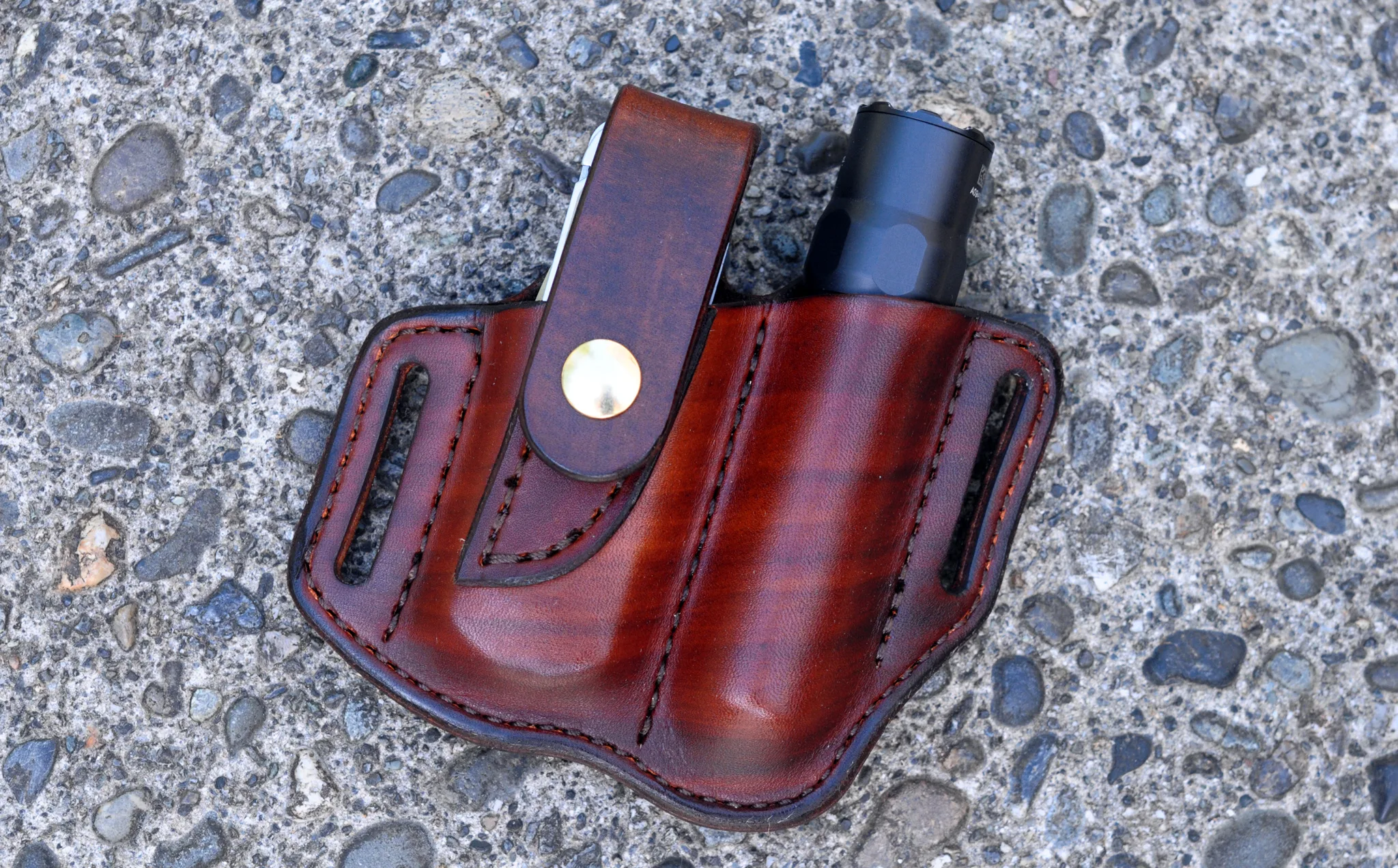 Front view of belt sheath for a Leatherman Free P4 multitool and flashlight shown in hand dyed mahogany leather