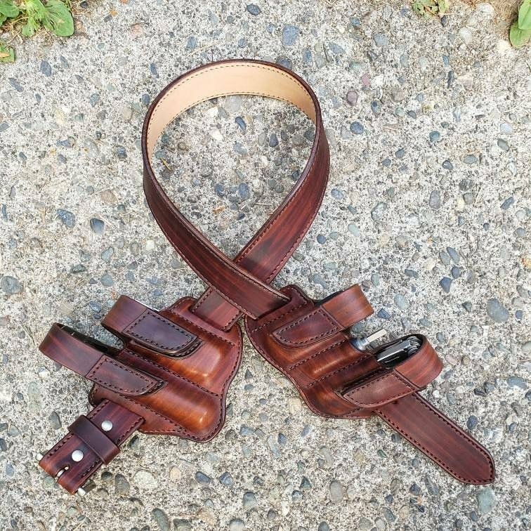 Front view of a Custom brown leather holster and belt set sitting on a cement surface